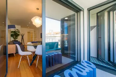 a living room and dining room with sliding glass doors at Chic Alves Apartment in Porto