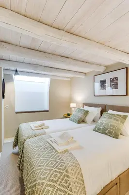 a bedroom with two beds and a window at Jardins da Muralha Apartments by DA'HOME in Porto