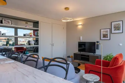 a living room with a table and chairs and a television at Rooftop Balcony at Porto Historic Center in Porto
