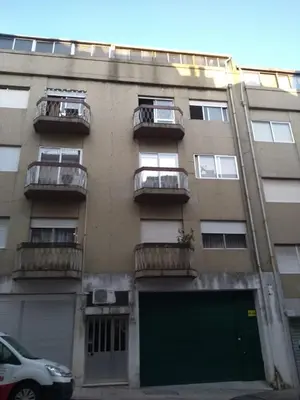 an apartment building with balconies and a green garage at Alegria Downtown Apartments in Porto
