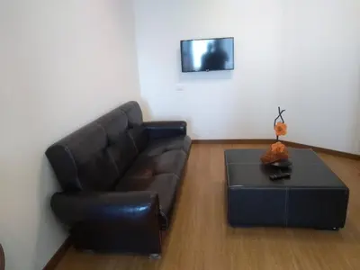 a living room with a black leather couch and a table at Alegria Downtown Apartments in Porto