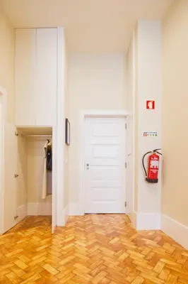 a hallway with a white door and wooden floors at Ribeira - Dixos Oporto Apartments III in Porto