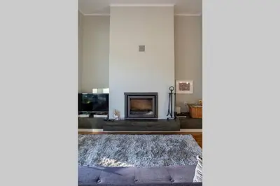 a living room with a fireplace and a rug at Virtudes Terrace in Porto
