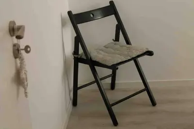 a black chair sitting in a corner next to a door at City Heart Place 3 in Porto