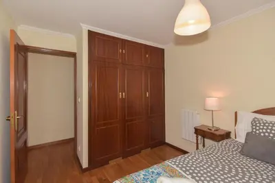 a bedroom with a bed and a wooden closet at Porto Downtown River in Porto