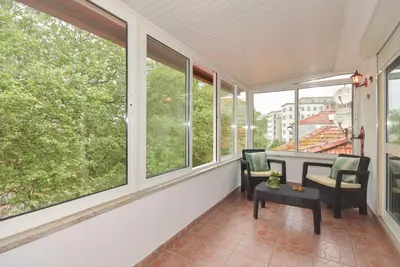 a balcony with two chairs and a table and windows at Porto Downtown River in Porto