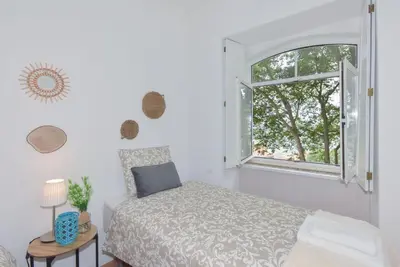 a bedroom with a bed and an open window at Porto Downtown River in Porto