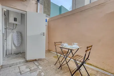 a table and chairs sitting on a patio with a wall at OPORTO GUEST Casa dos Clérigos in Porto