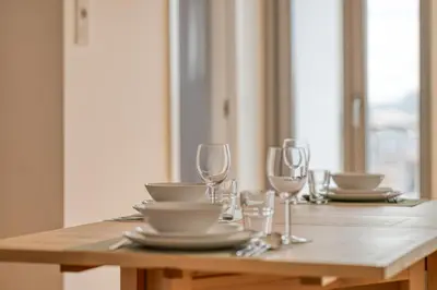 a wooden table with plates and glasses on it at OPORTO GUEST Casa dos Clérigos in Porto