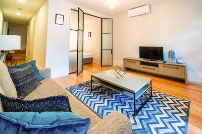 a living room with a couch and a tv at Morar Apartments Porto in Porto