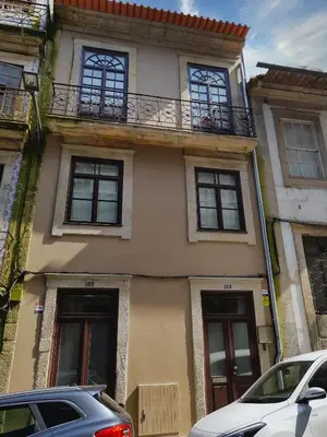 a building with a balcony and cars parked in front of it at Morar Apartments Porto in Porto
