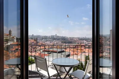 a balcony with tables and chairs and a view of a city at Morar Apartments Porto in Porto