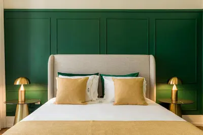 a bedroom with green walls and a bed with pillows at Almada Charm Suites & Apartments in Porto