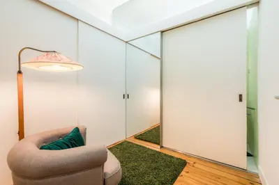 a living room with a chair and a mirror at Almada Charm Suites & Apartments in Porto