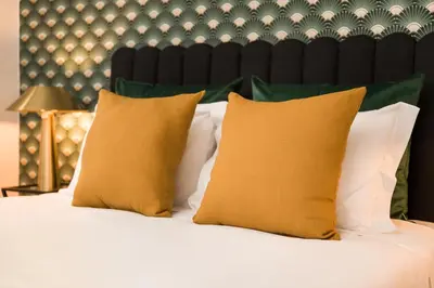 a bed with yellow and white pillows on it at Almada Charm Suites & Apartments in Porto