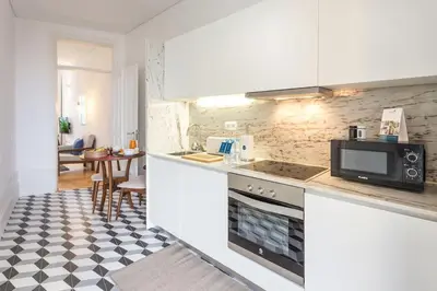 a kitchen with white cabinets and a stove top oven at Alegria 283 in Porto
