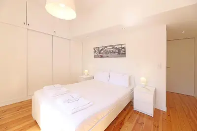 a bedroom with a white bed with two towels on it at FLH Porto City Mezzanine Apartment in Porto