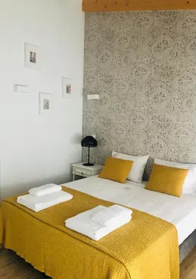 a bedroom with a bed with yellow and white sheets at Douro Pateo House in Vila Nova de Gaia
