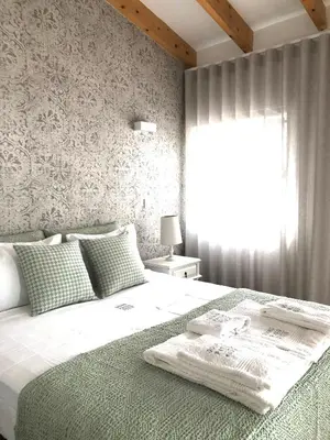 a bedroom with a large white bed with a window at Douro Pateo House in Vila Nova de Gaia