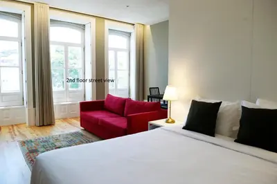 a bedroom with a bed and a red couch at Trendy Flats Fontainhas in Porto