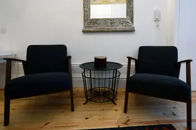 two chairs and a table in a room with a mirror at Trendy Flats Fontainhas in Porto