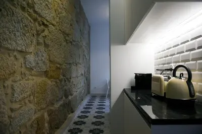 a bathroom with a stone wall and a counter with a kettle at Trendy Flats Fontainhas in Porto