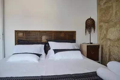 a bedroom with a bed with white sheets and pillows at Portoo Blue Apartments - Amazing in Vila Nova de Gaia