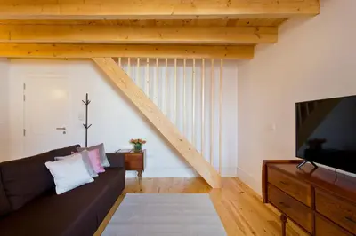 a living room with a couch and a tv at APOSENTUS - Clerigos Tower view Mezzanine in Porto