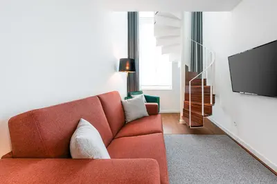 a living room with a red couch and a flat screen tv at Marques Design Apartments in Porto