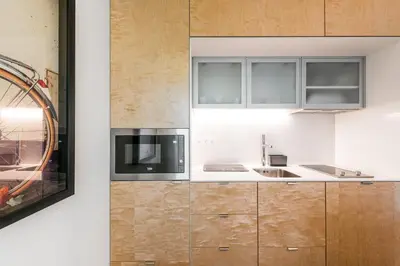 a kitchen with wooden cabinets and a microwave at Marques Design Apartments in Porto