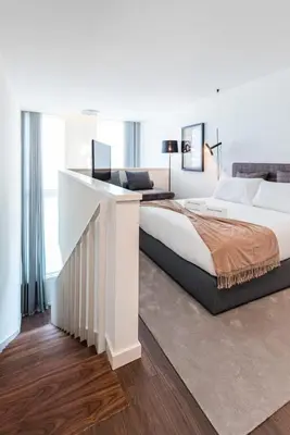 a white bedroom with a large bed and a desk at Marques Design Apartments in Porto