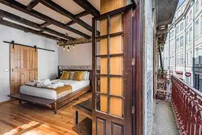 a bedroom with a bed and a balcony at GuestReady - CastleRock Pub & Hotel in Porto