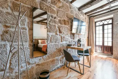 a bedroom with a large bed in a room with brick walls at GuestReady - CastleRock Pub & Hotel in Porto