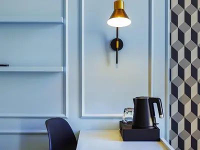 a living room with a blue couch and a table at Mercure Porto Centro Aliados in Porto
