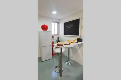 a kitchen with a small table and a refrigerator at T2P Mimosa House in Vila Nova de Gaia
