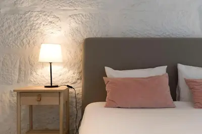 a bed with a lamp on a table next to it at Porto Garden Villa in Porto