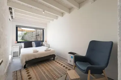 a bedroom with a bed and a blue chair at Porto Garden Villa in Porto