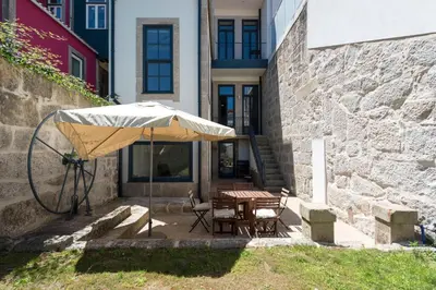 a table with an umbrella next to a building at Porto Garden Villa in Porto