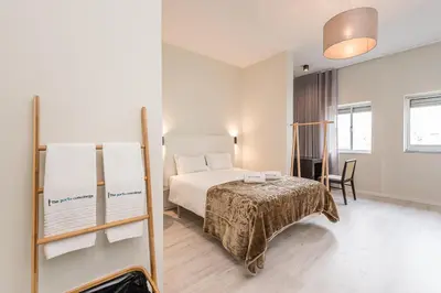 a bedroom with a bed and a table and a chair at River View Building in Vila Nova de Gaia