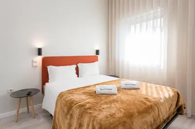 a bedroom with a large bed with two towels on it at River View Building in Vila Nova de Gaia