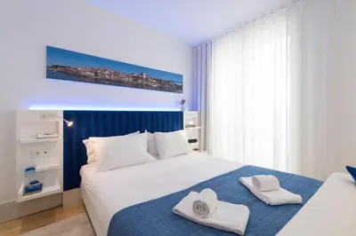 a bedroom with a white bed with towels on it at Heart of D Pedro Apartments in Porto