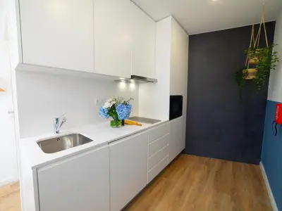 a kitchen with white cabinets and a sink at Ponte D Luis I Apartments in Porto