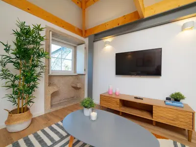 a living room with a tv and a table at Ponte D Luis I Apartments in Porto