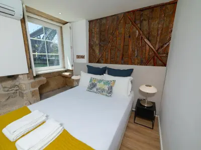 a bedroom with a large white bed and a window at Ponte D Luis I Apartments in Porto
