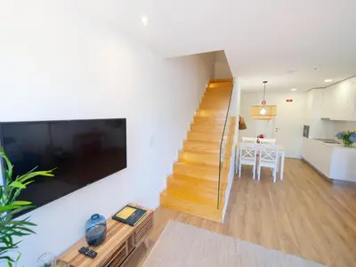 a living room with a staircase and a dining room at Ponte D Luis I Apartments in Porto