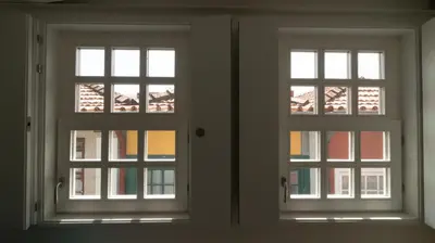 two windows in a room looking out at a building at Souto Apartments in Porto