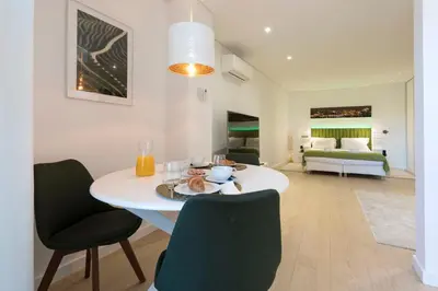 a dining room with a white table and chairs at Heart of D. Pedro Apartments III in Porto