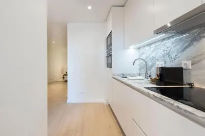 a kitchen with white walls and a counter with a sink at Heart of D. Pedro Apartments III in Porto