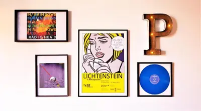 a wall with four framed posters and a cd at Art District - POP & ROCK Apartments in Porto
