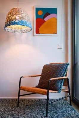 a chair in a room with a painting and a lamp at Art District - POP & ROCK Apartments in Porto